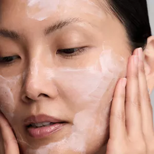 Nahaufnahme einer Person, die Comforting Barrier Mask auf ihr Gesicht aufträgt, wobei die cremige Textur zu sehen ist